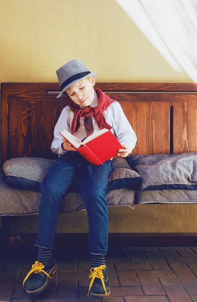 Glücklicher Stilvoller Junge Mit Einem Buch Auf Der Bank — Stockfoto