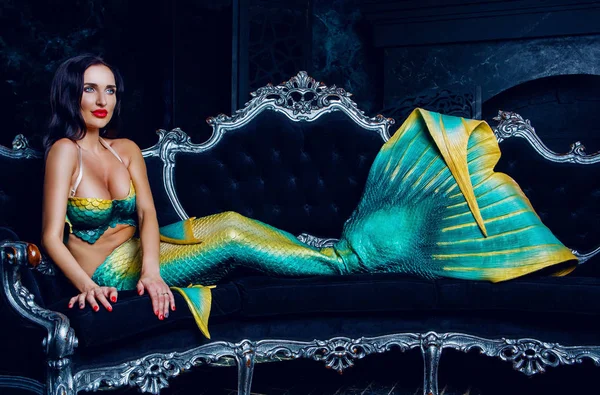 model dressed as a mermaid , on the sofa