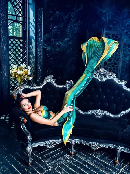 model dressed as a mermaid , on the sofa