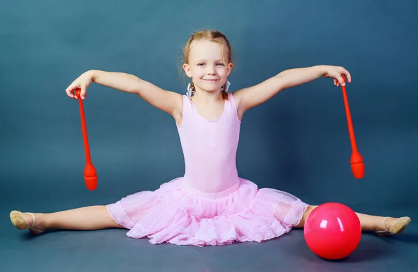 Dívčí gymnasta s míčem a kluby — Stock fotografie