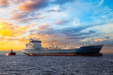 Tanker ve günbatımı denizde römorkörde