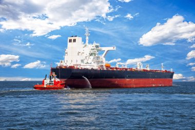 Tanker yardımcı olmak için yaklaşan kırmızı römorkör tekne