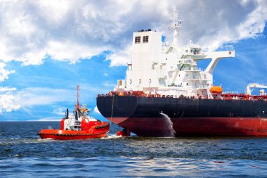 Tanker yardımcı olmak için yaklaşan kırmızı römorkör tekne