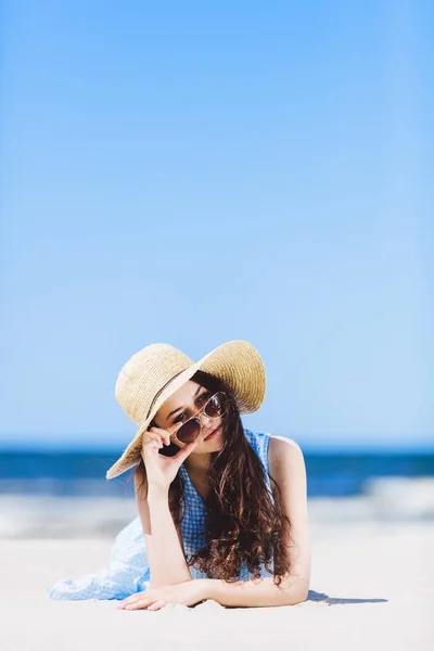在沙滩上躺着草帽的年轻漂亮女人 拿着太阳镜 夏季休闲 — 图库照片