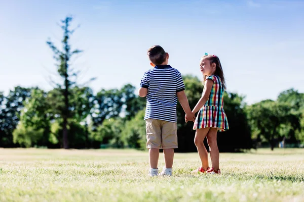 男の子と女の子が公園で手をつないで — ストック写真