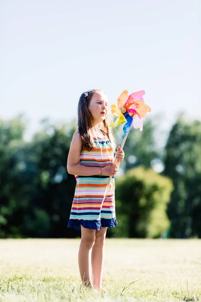 Little Girl Colorful Dress Blowing Pinwheel Park — Stock Photo, Image