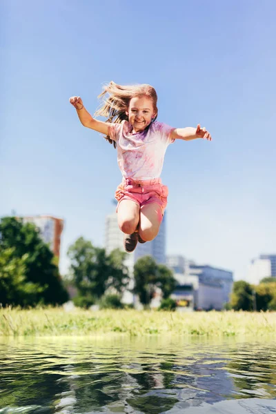 Menina Saltando Alto Acima Grande Poça Água Brincar Fora — Fotografia de Stock