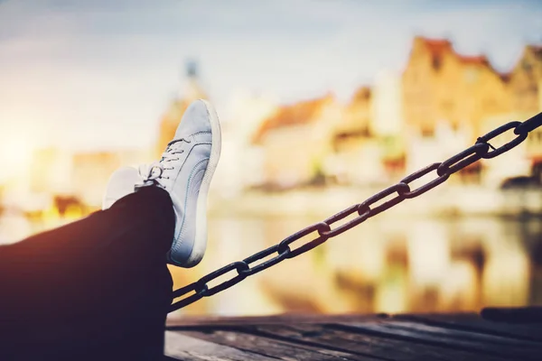 Female Legs Leaning Chain River Old Buildings Blurred Background — Stock Photo, Image