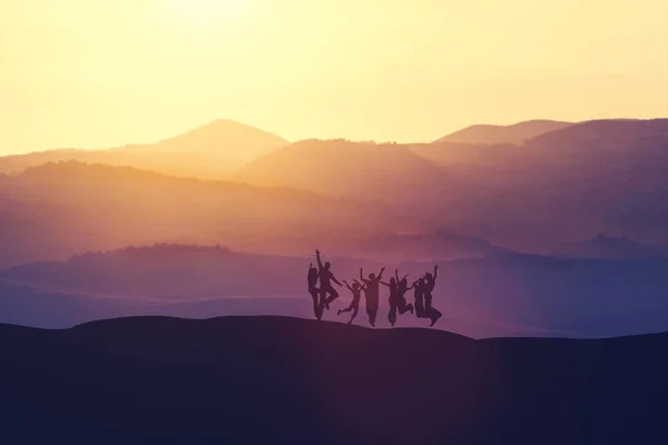 Grupo Pessoas Pulando Alto Colina Durante Pôr Sol Alegria Felicidade — Fotografia de Stock