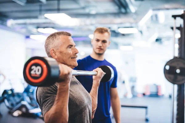 Older Man Lifting Weights Supervised Gym Assistant Sporty Lifestyle Elderly — Stock Photo, Image