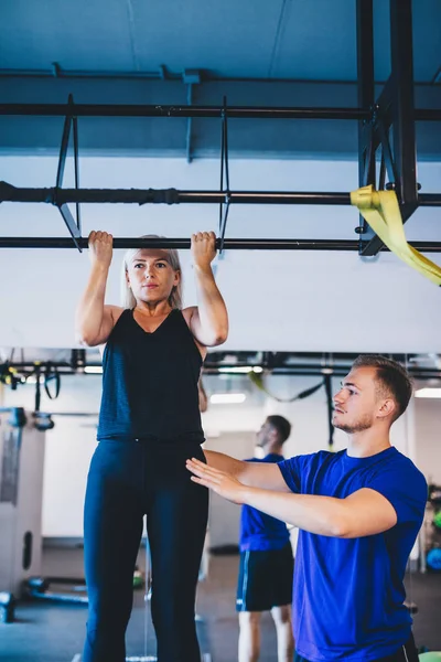 Woman Doing Pull Ups Man Securing Her Personal Trainer Workout — Stock Photo, Image