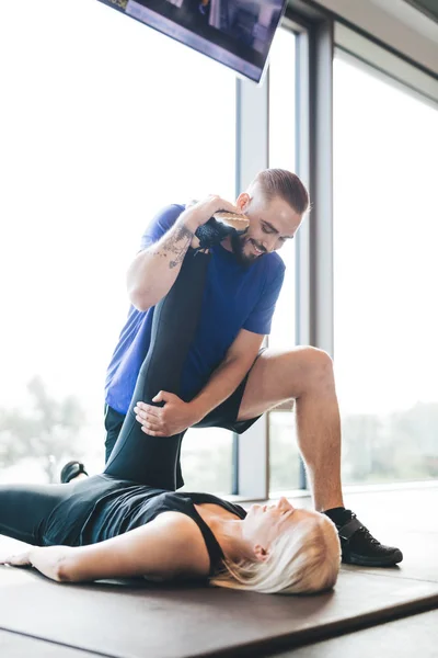 私人教练伸展女人的腿 锻炼帮助 运动的生活方式 — 图库照片