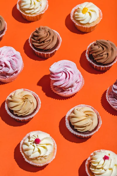 Färgglada Cupcakes Rader Orange Bakgrund Söta Läckra Desserter — Stockfoto