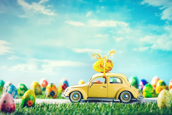 おとぎ話春の風景で屋根の上のイースターエッグとレトロなおもちゃの車 — ストック写真