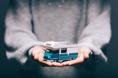 Close view of woman holding camper car in hands clipart