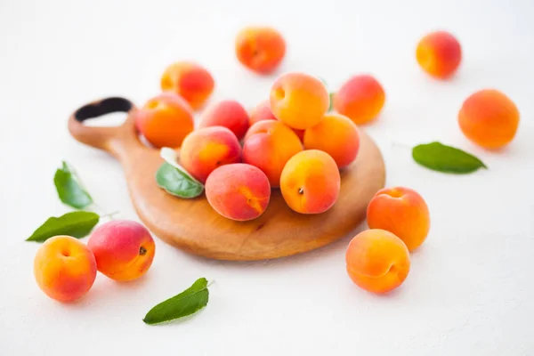 Nahaufnahme Eines Haufens Frischer Aprikosen Auf Einem Holzschneidebrett Mit Grünen — Stockfoto