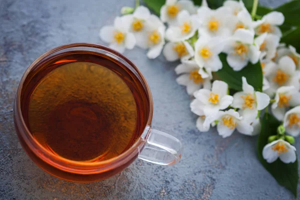 ジャスミン茶と暗い背景の葉新鮮な白い花のカップ — ストック写真