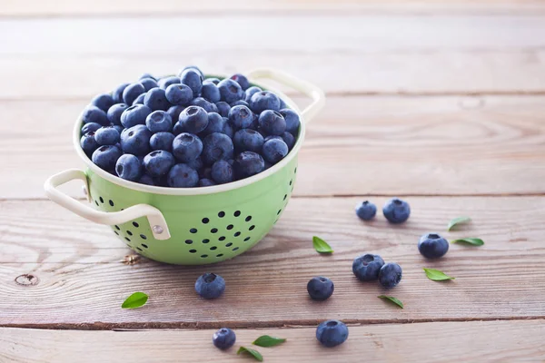 Green Colander Full Blueberries Wooden Table — Stock Photo, Image