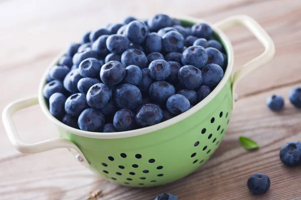 Green Colander Full Blueberries Wooden Table — Stock Photo, Image