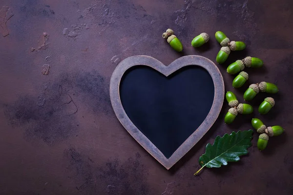 Herbststimmung Kreidetafel Herzform Und Grüne Eicheln Mit Blatt Auf Dunkelviolettem — Stockfoto