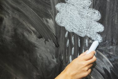 Bir tahtaya tebeşir ile çizilmiş bir yağmur ve bir bulut