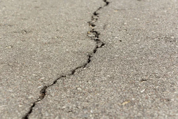 yüzeyi boyunca yayılan çatlaklar ile asfalt.