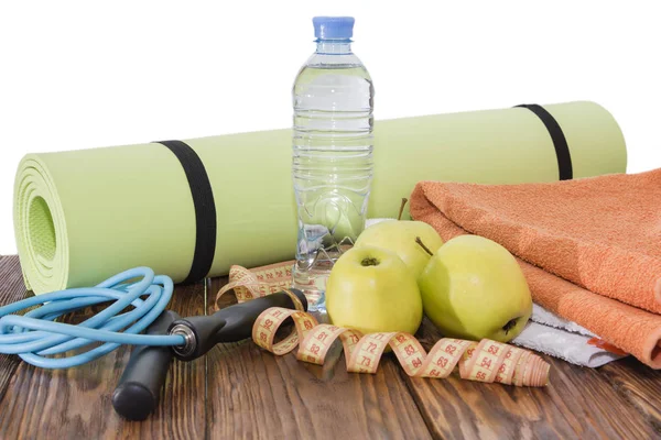 Yoga Mat y botella de agua de cerca. Equipamiento deportivo, tres manzanas verdes y una cuerda de salto . — Foto de Stock