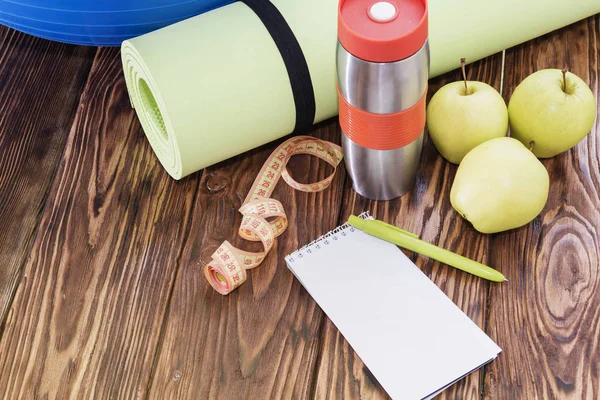Yoga Mat ve su şişesi yakın çekim. Spor malzemeleri, üç yeşil elma