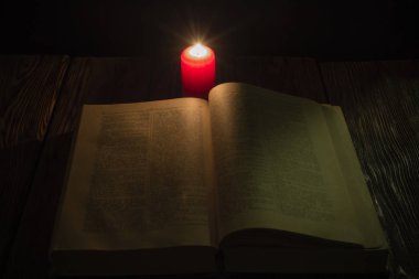 mum ve İncil'in geceleri ahşap arka plan üzerine bir kitap
