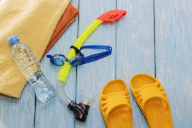 Maske ve şnorkel, açık su şişesi, Dalış gözlüğü parlak slates üzerinde ahşap arka plan mavi.