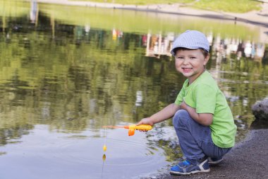 boy fishing on the lake, the concept of sport fishing. clipart