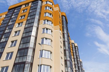 Güneşli bir günde gökyüzüne karşı modern apartman binası.