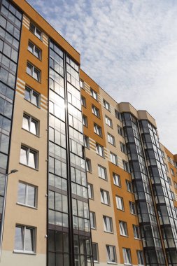 Güneşli bir günde gökyüzüne karşı modern apartman binası.