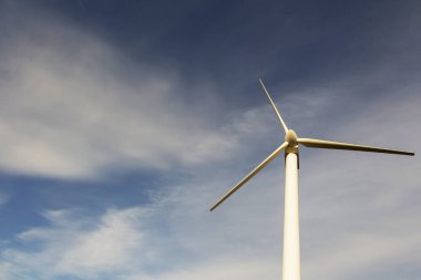 mavi gökyüzü arka plan üzerinde rüzgar jeneratörü. elektrik üretimi. metin için yer