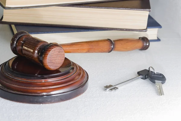 Judge hammer and house key on light background. The concept of property law. Estate sale.