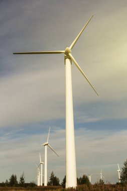 mavi gökyüzü arka plan üzerinde rüzgar jeneratörü. elektrik üretimi. metin için yer. gün batımında