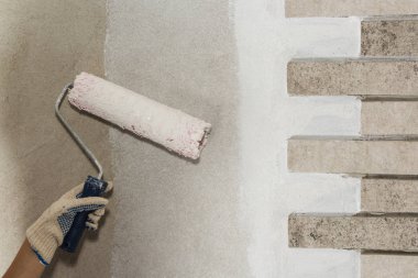 Ressam yakın bir duvar boya silindiri ile boyuyorum