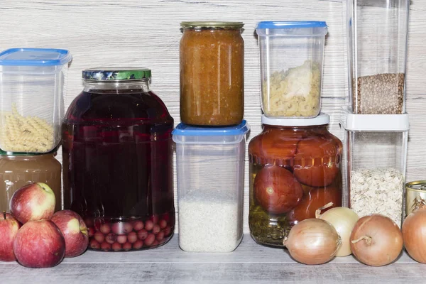 Storage shelves in pantry with homemade canned preserved fruits and vegetables.