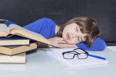 Genç güzel zor çalışma kız öğrenci kitaplarını bir yığın üzerinde okurken uykuya daldı.