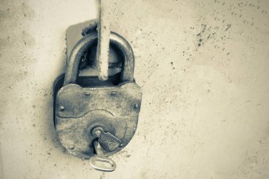 Eski paslı kilit gri arka plan, siyah ve beyaz fotoğraf bir üstünde bir anahtar ile.