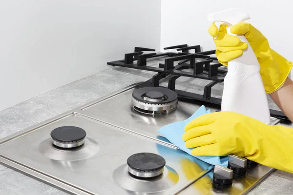 Limpeza de um fogão a gás com utensílios de cozinha, conceitos domésticos, ou higiene e limpeza. — Fotografia de Stock