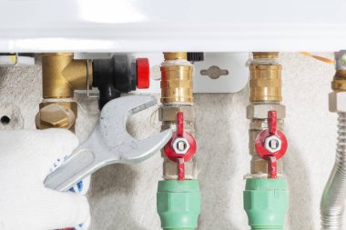 Bir gaz borusu kazan bir anahtar ile bir tesisatçı ekler