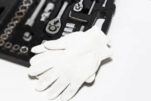 Box with tools and work gloves in a car repair shop, close-up. Set of many chrome vanadium tools