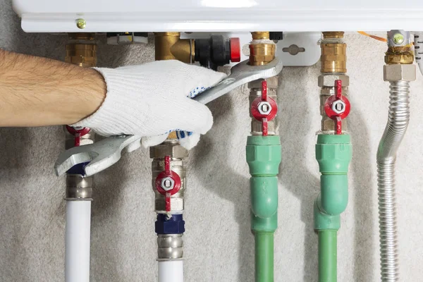 Bir gaz borusu kazan bir anahtar ile bir tesisatçı ekler