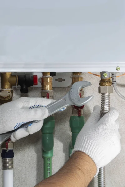 Bir gaz borusu kazan bir anahtar ile bir tesisatçı ekler.