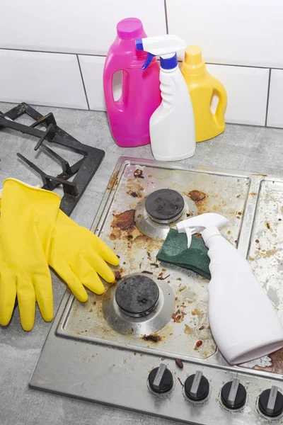 Limpeza de um fogão a gás com utensílios de cozinha, conceitos domésticos, ou higiene e limpeza. — Fotografia de Stock