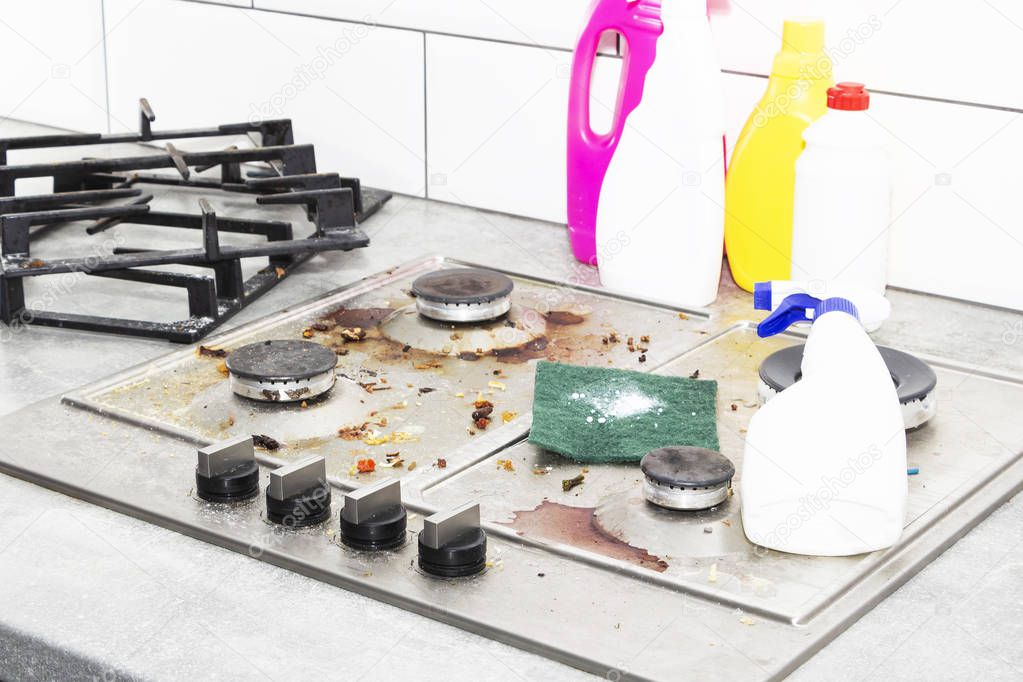 Cleaning a gas stove with kitchen utensils, household concepts, or hygiene and cleaning.