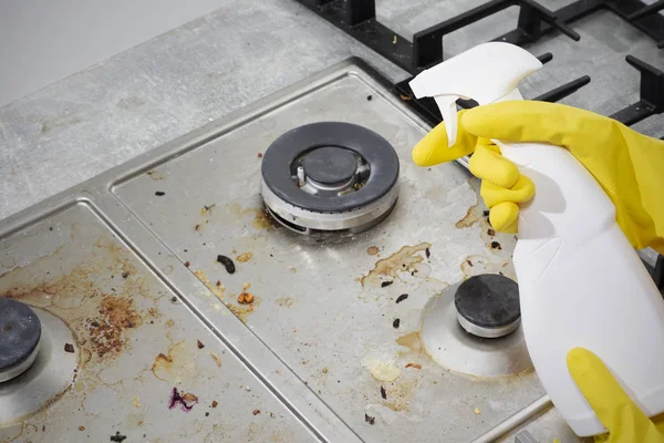 Cleaning a gas stove with kitchen utensils, household concepts, or hygiene and cleaning. Stock Picture