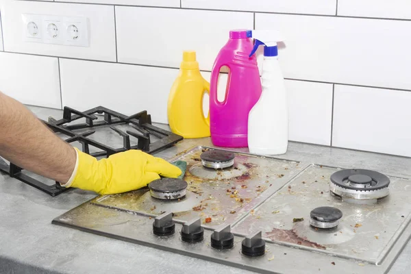 Limpeza de um fogão a gás com utensílios de cozinha, conceitos domésticos, ou higiene e limpeza. — Fotografia de Stock