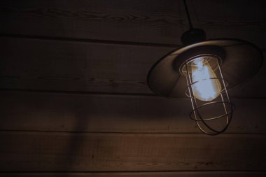 Eski moda vintage fener lamba ile yumuşak bir yanan ışık yaşlı ahşap duvar ile bir antika rustik ülke ahırda kızdırma ve ahşap zemin yıpranmış